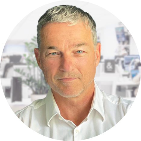 Portraitfoto von Dr. Christian Derichs im Anzug vor einem unscharfen Hintergrund