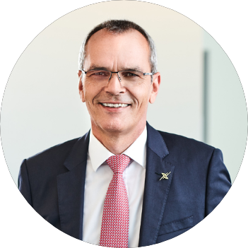 Portraitfoto von Dr. Stefan Müller im Anzug vor einem unscharfen Hintergrund